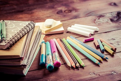 School supplies with exercise book and notepads on wooden background. Back to school concept