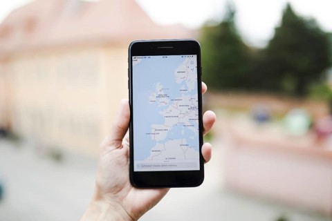 Human hand holding mobile phone with map gps navigation screen