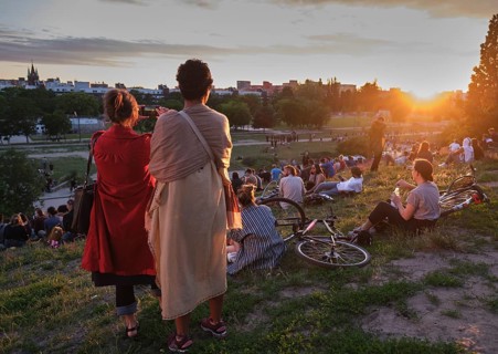 Germany, Berlin, 21. 206. 2020, Mauerpark, two woman, mobile phone photo, visitors on the meadow,