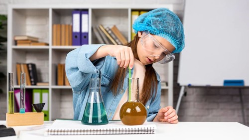 Girl with hair net doing science experiments with test tubes