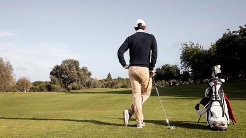 Man with golf clubs copy space field