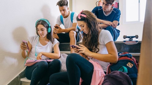 Group schoolkids looking smartphones