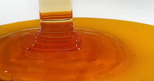 Honey Flowing against White Background