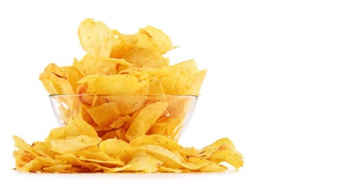 Composition with bowl of potato chips isolated on white