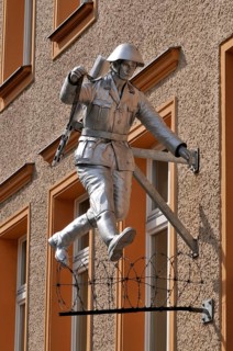 Jumping soldier, barbed wire, house wall, sculpture Jump, by Conrad Schumann, Wall memorial,
