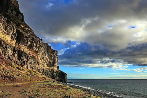 Lonely beach with cliffs on the Atlantic Ocean in the Canary Islands. Playa de Tasarte, Las Palmas,
