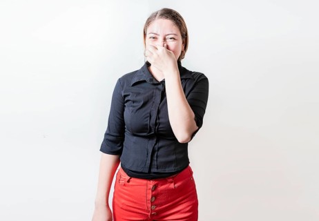 Displeased person holding her nose isolated. Disgust young girl covering nose. Woman covering nose