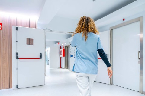 Rear view of a nurse in a rush along the emergency area of an hospital