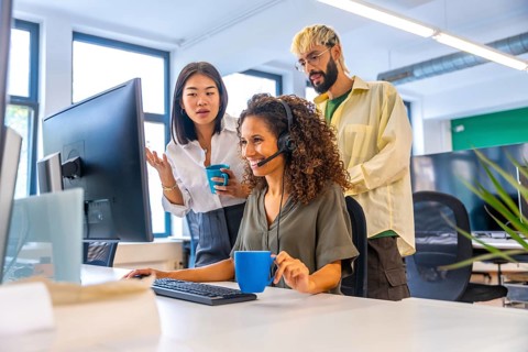 Coworkers drinking coffee while making a video call suing headset
