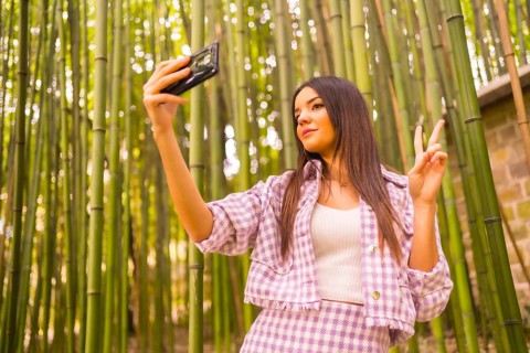 Young caucasian girl with a pink skirt in a bamboo forest. Enjoying summer holidays in a tropical