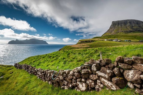 View of the island of Mykines, old stone wall, Gásadalur village, Vágar, Faroe Islands, Denmark,