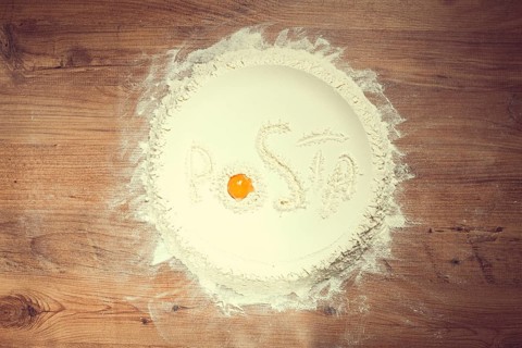 Flour on a wooden table, top view, inscription Pasta, with egg yolk, cooking, food concept, no