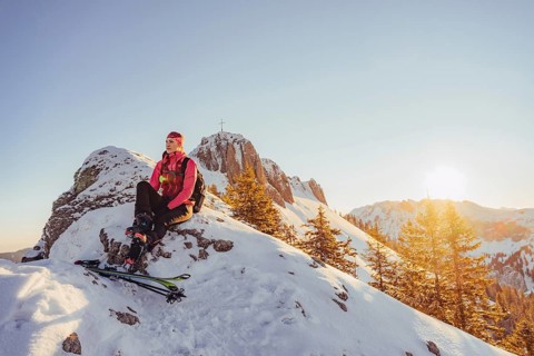 A woman's ski tour at sunrise on the Tegelberg in the Allgäu in the Ammergebirge, Bavaria, Germany,
