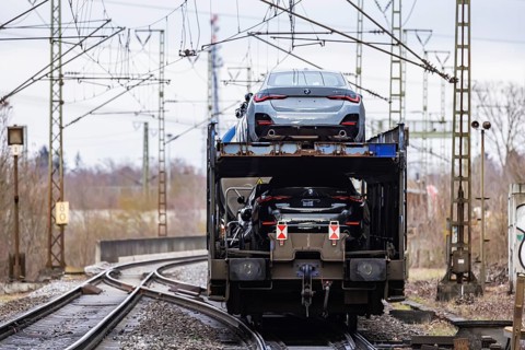 Goods train travelling on the winding Schuster Railway, overhead lines and infrastructure. Car