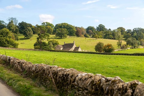 Cotswolds landscape of fields, trees, farmhouse building, near Yanworth, Gloucestershire, England,