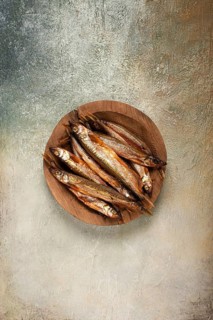 Cold smoked capelin, on a wooden bowl, top view, no people