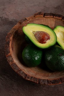 Fresh, sliced avocado, in a wooden plate, top view, food background, concept, food styling