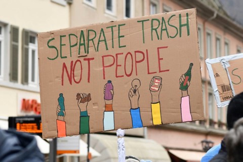 Heidelberg, Germany - February 12th 2025: Person holding up sign with text 'Separate trash not
