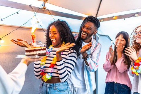 Multiracial young group of friends at terrace together celebrating with sparkling lights a summer