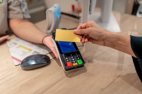 Close-up of a client paying using contactless credit card in a pharmacy