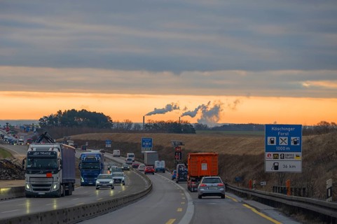 Evening traffic on the A9 motorway, smoking chimneys behind, Bavaria, Germany, Europe