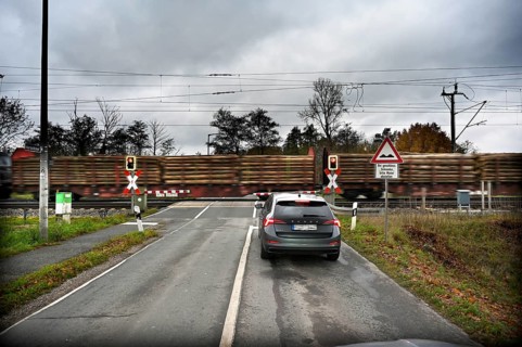 Passing goods train at a level crossing with barriers, Fürth, Middle Franconia, Bavaria, Germany,