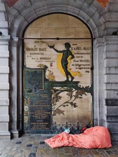 Homeless person in front of a façade detail at the L'Étoile guildhall, Grand-Place, Grote Markt,