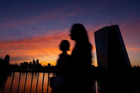 The light of the setting sun colours the sky behind the European Central Bank (ECB) and the