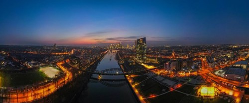 The lights of the European Central Bank (ECB) and the Frankfurt banking skyline glow in the evening