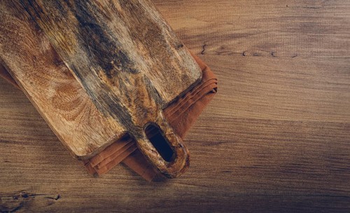 Square, chopping wooden board, chopping board with handle, on a kitchen towel, rustic style, top