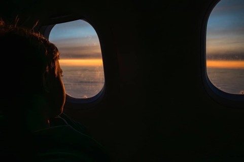 Boy looking throw the window in the flying airplane