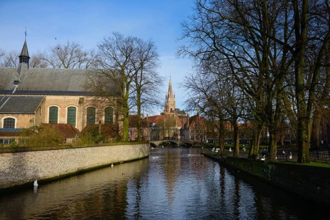 View of canal and Church of Our Lady from Begijnhof, Brugge, Belgium, Europe