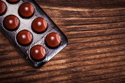 Blister pack with pills on vintage wooden board