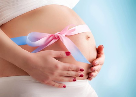 Pregnant pretty belly with colored ribbon. Third trimester