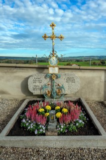 Grave with heather (Erica), near St George and St Florian, a listed Catholic parish church in