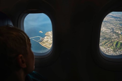 Boy looking throw the window in the flying airplane
