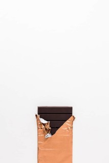 Dark chocolate bar golden wrapper white background