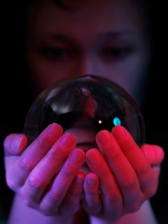 Woman looking into a crystal ball in her hands