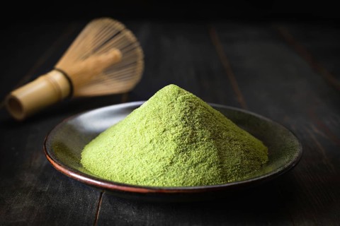 Japanese matcha green tea in a cup and tea powder close-up
