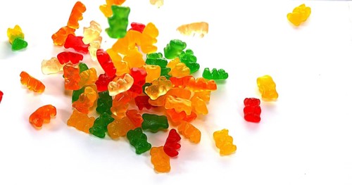 Gold Bears or Gummy Bears falling against White Background