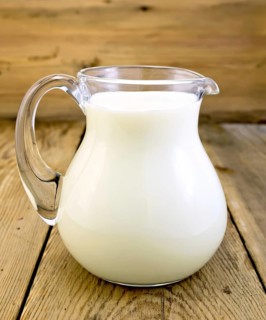 Milk in a glass jar on a wooden boards background