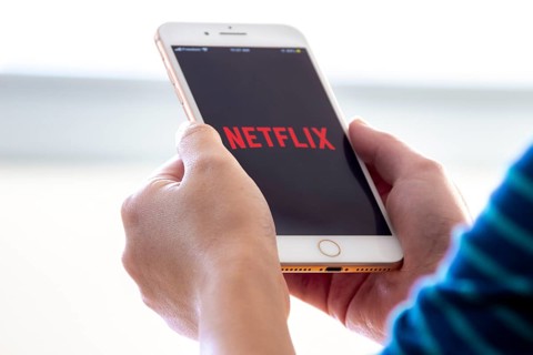 Calgary, Alberta. Canada Nov 28 2019: Woman holds an iphone plus with the Netflix app on her hands.