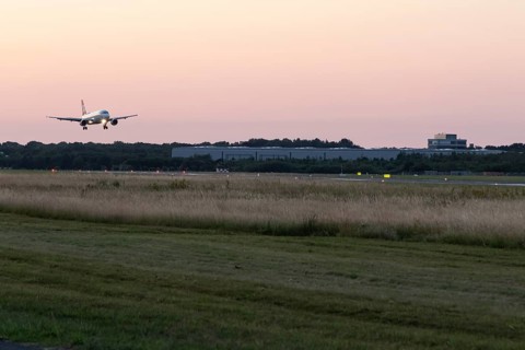 Passenger aircraft Airbus A320-214 of Austrian Airlines at dusk during landing at Hamburg Airport,