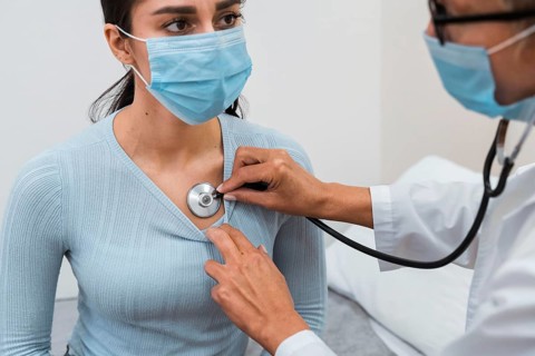 Woman checking patient with stethoscope