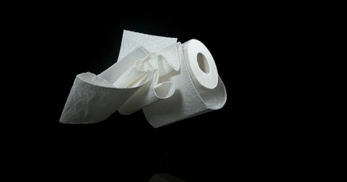 Roll of Toilet Paper Falling on Black Background
