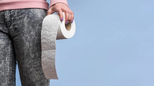 Front view person holding toilet paper roll with copy space