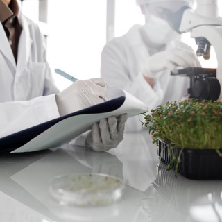 Researchers with clipboard biotechnology laboratory