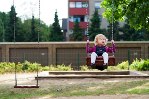 Little girl sitting on a swing