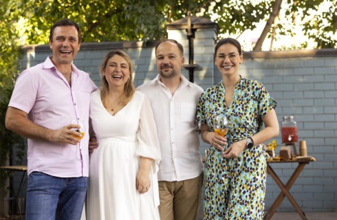 Group of beautiful happy people communicating and smiling while spending time on weding outdoors