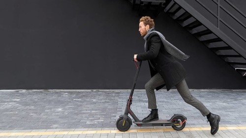 Handsome male riding electric scooter